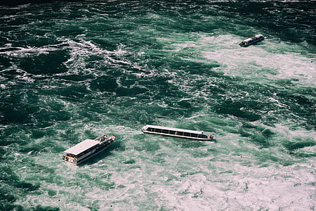 white and blue boat in ocean at daytime thumbnail
