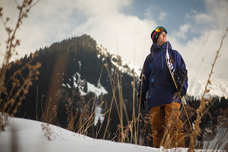 Low Angle Photography of Man Wearing Blue Jacket Carrying Snow Board thumbnail