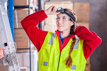 photo of woman in black headlamp, red long sleeve zip up work suit and yellow work vest thumbnail