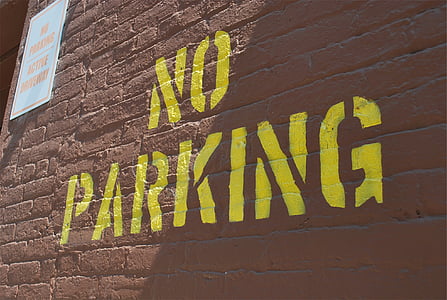 No Parking sign on brown concrete wall thumbnail