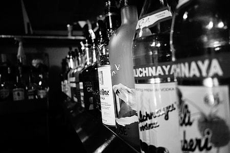 grayscale photography of labeled bottles thumbnail