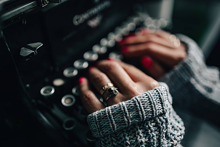 Woman typing on an old typewriter thumbnail