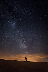 person standing on field under starry sky thumbnail