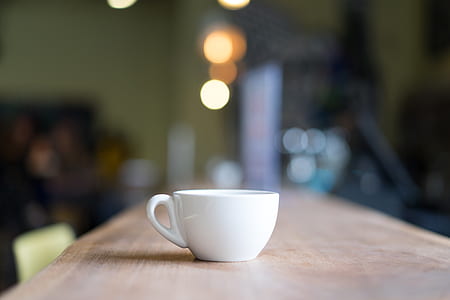 selective focus photograph of white ceramic teacup on wooden surface thumbnail