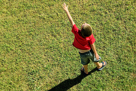 boy standing on green grass field thumbnail