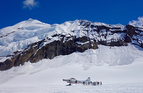 people standing beside plane near snowy mountain thumbnail