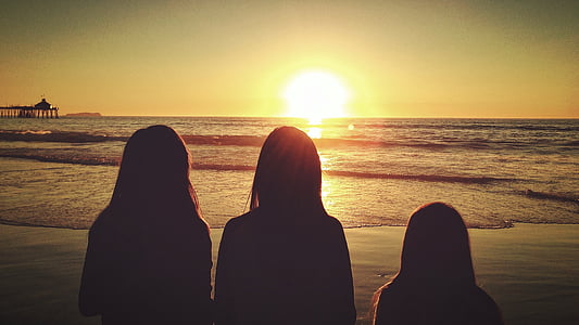 silhouette of three persons standing on seashore thumbnail