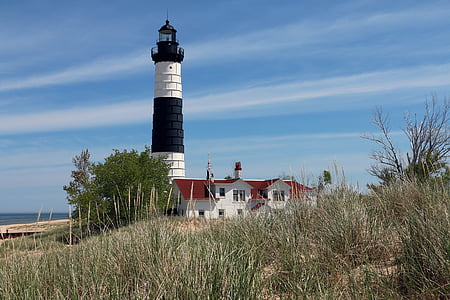lighthouse beside red painted house thumbnail