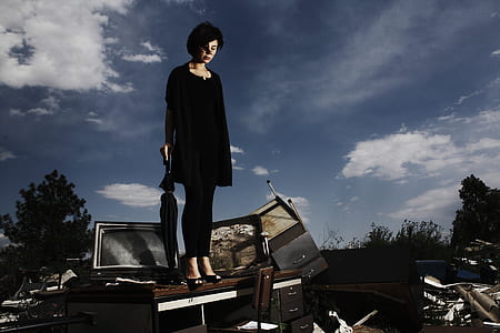 woman wearing black shirt standing on brown wooden table with umbrella during daytime thumbnail