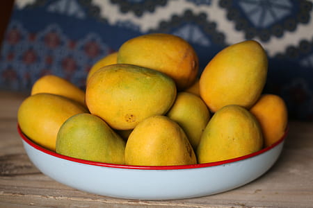 yellow mangoes on white and red plate thumbnail