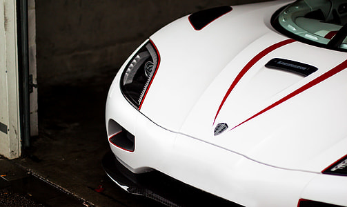 white Koenigsegg parked inside garage thumbnail
