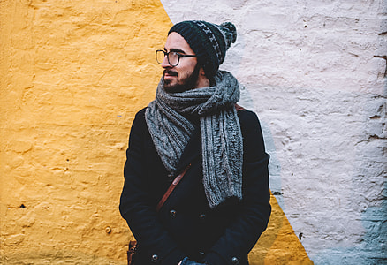 man in grey scarf leaning on wall thumbnail