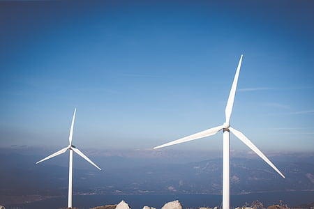 two white wind turbine under blue sky thumbnail