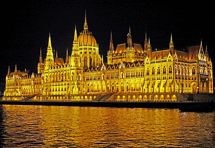 brown concrete building surrounded by body of water at nighttime thumbnail
