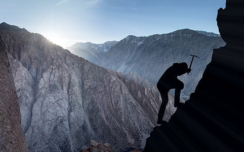 person climbing on mountain silhouette photo thumbnail