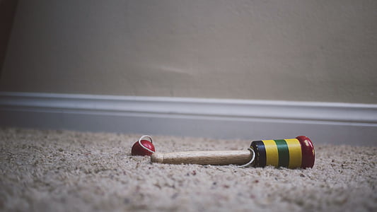 brown and multicolored wooden toy on rug thumbnail