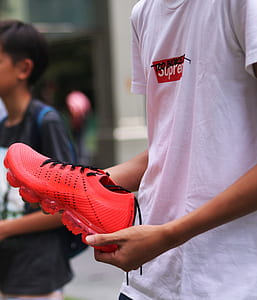 man holding red Nike Air VaporMax shoe thumbnail