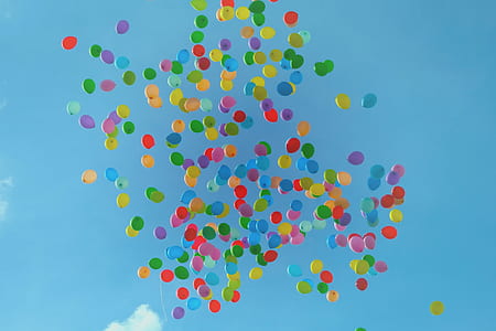 assorted-color flying balloons under blue sky at daytime thumbnail