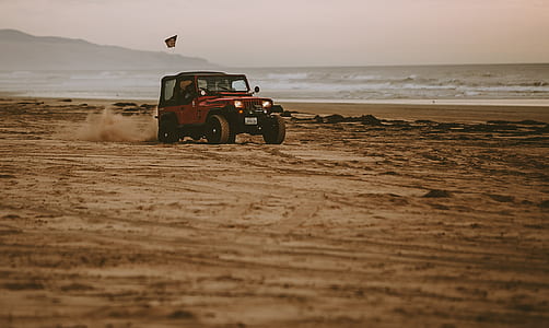 red Jeep Wrangler on beach thumbnail