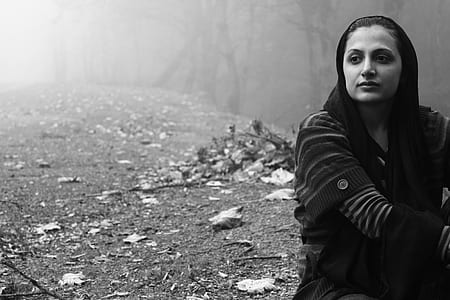grayscale photo of woman sits on ground soil thumbnail