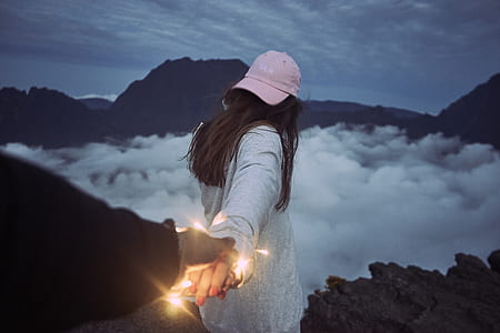 man holding woman's hand on mountain top thumbnail