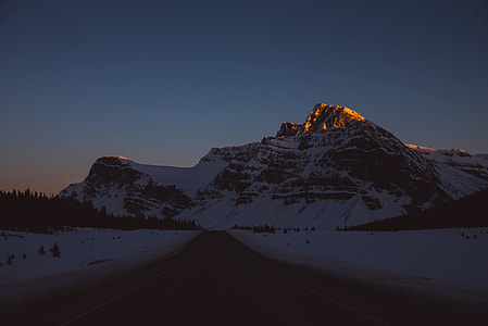 highway through snow-covered mountain during daytime thumbnail