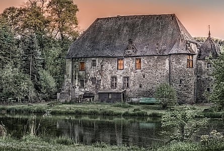 grey concrete house surrounded by water and trees thumbnail