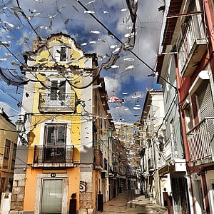 pathway surrounded by building with buntings at daytime thumbnail