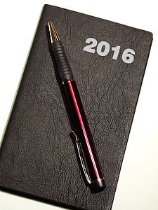 pen on black leather book thumbnail