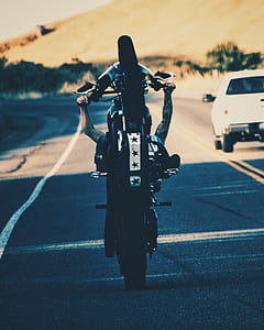 man performing stunt using motorcycle on road thumbnail