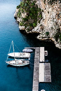 two yachts dock on port near rock formation thumbnail
