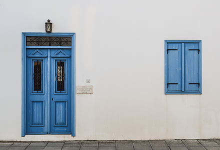 white concrete wall with blue door and window thumbnail