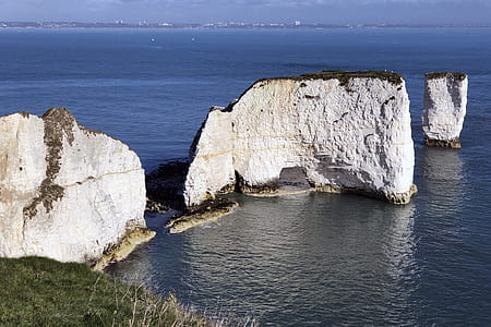 three white rock formations near body of water thumbnail