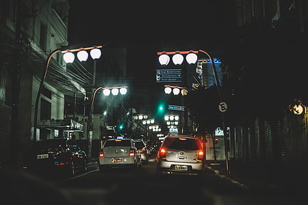vehicles on road beside street lamps during night time thumbnail