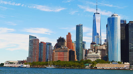 Battery Park with Lower Manhattan skyline looming behind on a sunny summer day. thumbnail