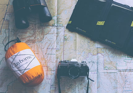 photo of Canon DSLR camera beside binocular, bag, and case, on map thumbnail