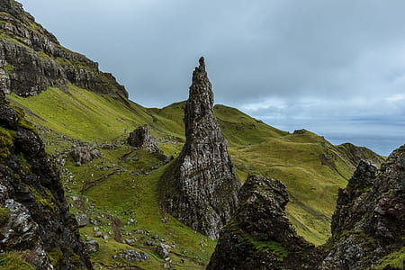 black stone formations on green hill thumbnail