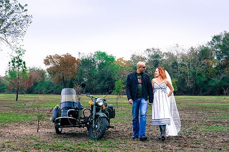 Man and Woman Holding Each Other Hand Beside Grey Motorcycle With Side Trailer thumbnail