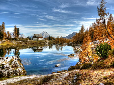 panoramic photography of house near body of water and mountain under blue skies at daytime thumbnail