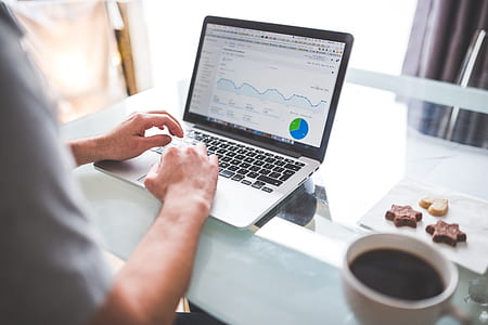 person using laptop beside mug on table thumbnail
