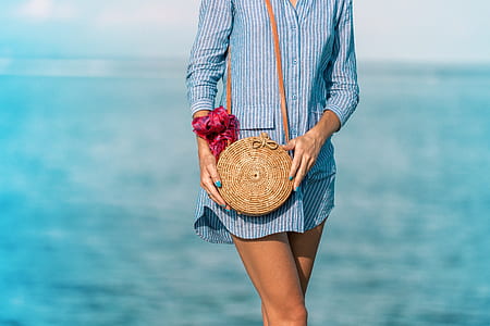 woman walking under broad daylight near body of water thumbnail