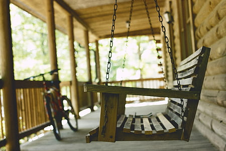 brown wooden swing chair near bike thumbnail