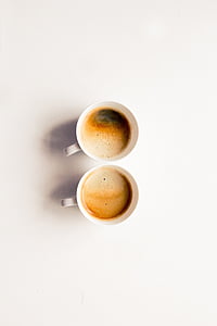 two white coffee mugs on white surface thumbnail