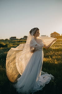 woman in white dress standing in green grass field thumbnail