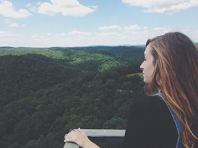 woman looking at green trees and mountain thumbnail