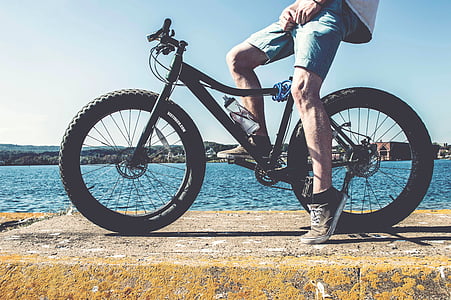 man riding bike with fat tires near body of water thumbnail