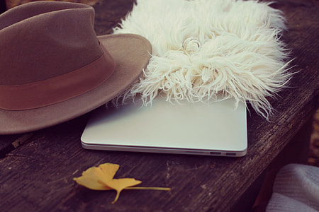 white fur with brown hat and white device on brown surface thumbnail