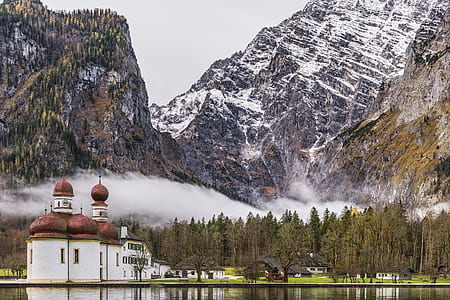 red and white temple in front of grey snow-covered mountains thumbnail