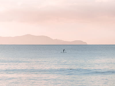 Man Rowing a Boat on Sea at Daytime thumbnail