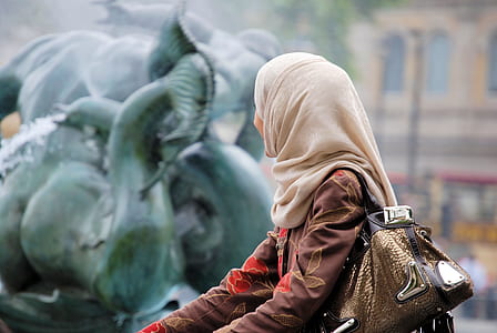 woman sitting near statue at daytime thumbnail
